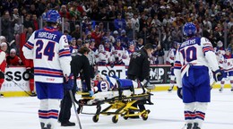 Cole Hutson na nosidlách po údere pukom.