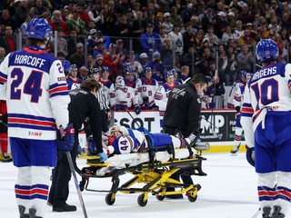 Cole Hutson na nosidlách po údere pukom.