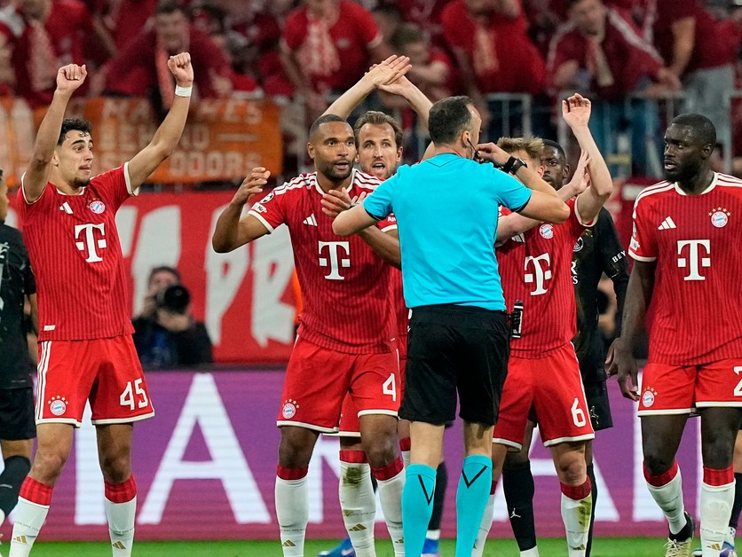 Hráči Bayernu hromžia na rozhodcu. 