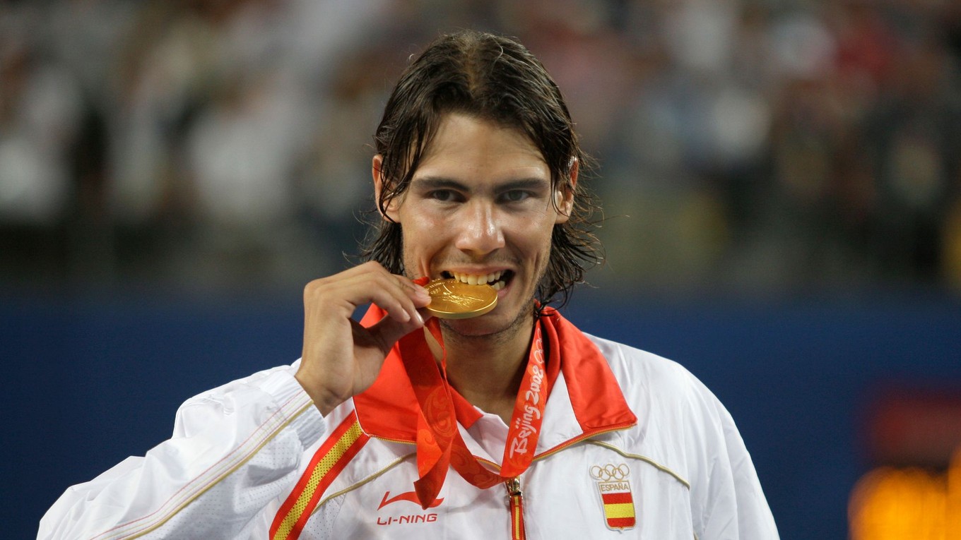 Španielsky tenista Rafael Nadal sa zahryzáva do zlatej medaily  na OH 2008 v Pekingu 2008.