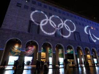 Olympijské kruhy sú premietané na fasádu budovy pred gotickou katedrálou Duomo v Miláne v Taliansku.