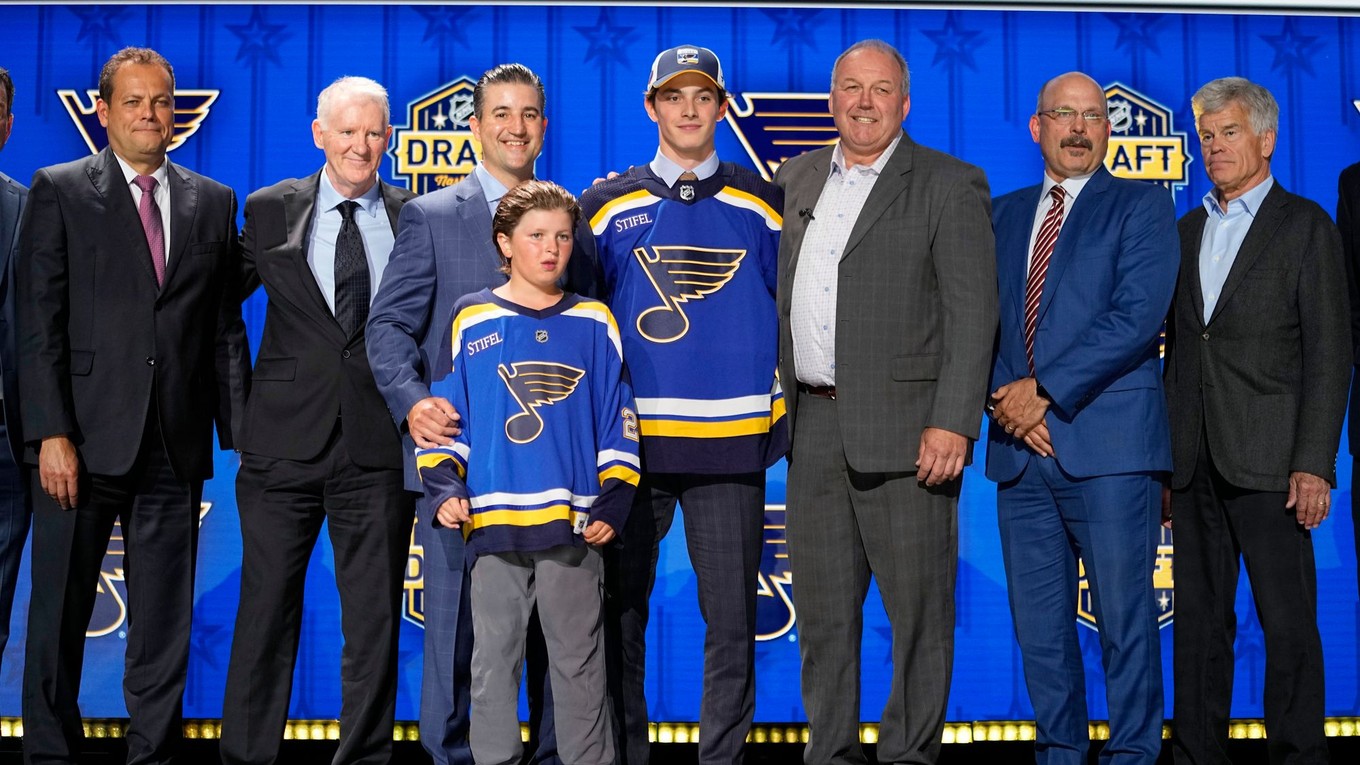 Dalibor Dvorský (uprostred) pózuje v drese St. Louis Blues počas draftu NHL 2023.