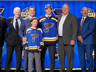 Dalibor Dvorský (uprostred) pózuje v drese St. Louis Blues počas draftu NHL 2023.