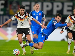 Slovenský obranca Ľubomír Šatka padá medzi nemeckých hráčov Aleksandara Pavloviča (vľavo) a Nica Schlotterbecka.