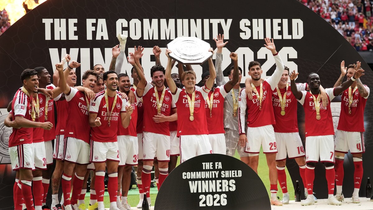 Hráči Arsenalu oslavujú a uprostred Martin Odegaard zdvíha trofej po ich víťazstve v Community Shield.