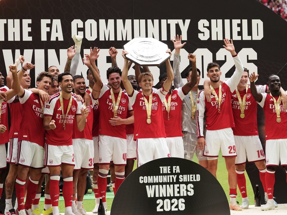 Hráči Arsenalu oslavujú a uprostred Martin Odegaard zdvíha trofej po ich víťazstve v Community Shield.