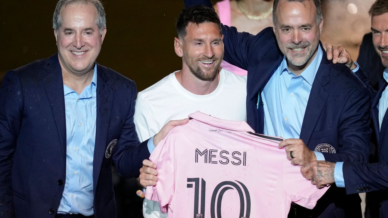 Lionel Messi (uprostred) drží svoj nový dres Interu Miami a pózuje so spolumajiteľmi tímu Jorgem Masom (vľavo), Josém Masom (druhý sprava).