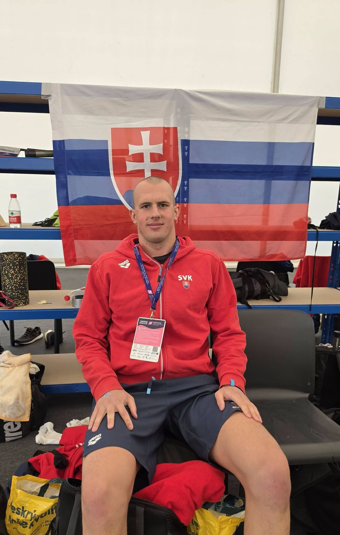 Plavec Richard Urban pred slovenskou vlajkou v dejisku pretekov.