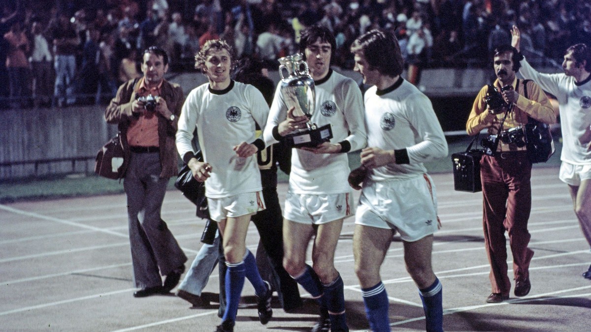 Zľava Ján Pivarník, Anton Ondruš a Ladislav Jurkemik už v nemeckých dresoch a s trofejou po finále ME 1976 vo futbale.