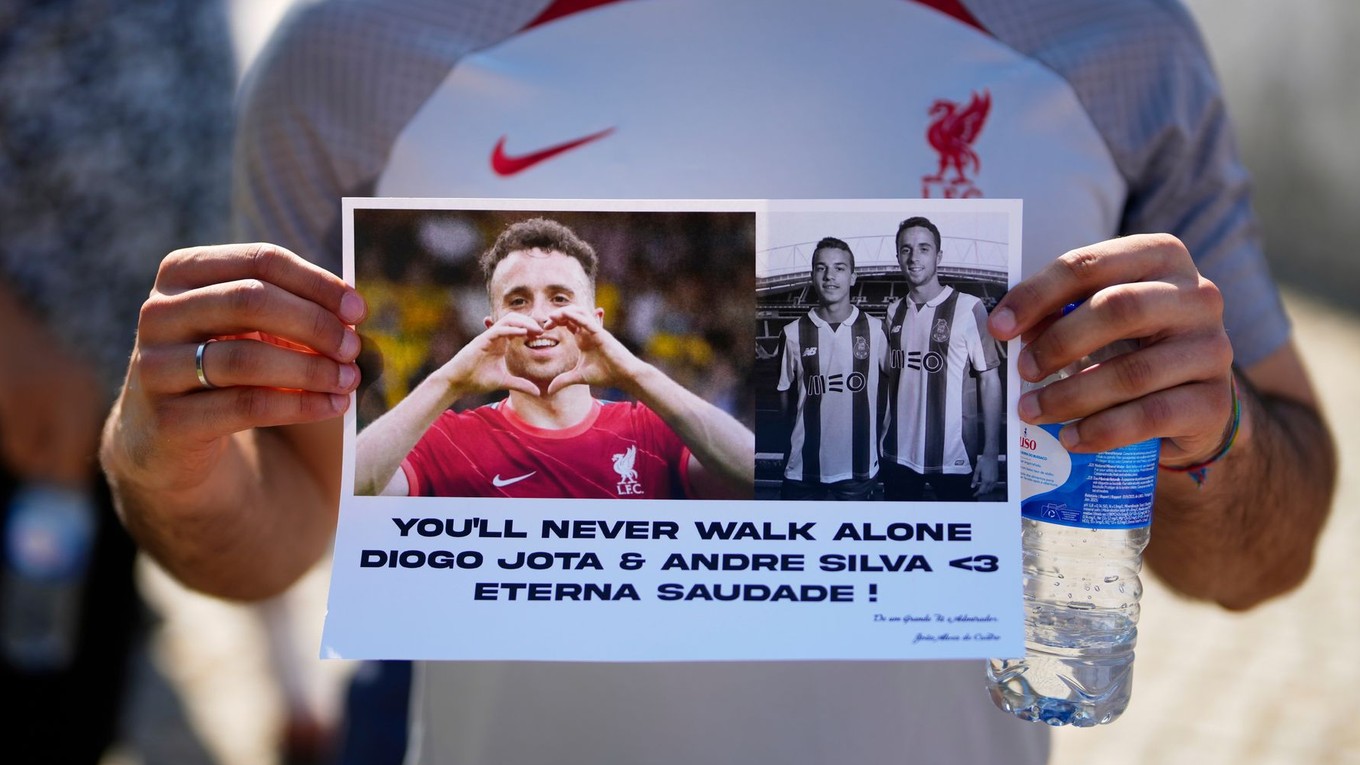 Fanúšik drží transparent s fotografiami Dioga Jotu a Andrého Silvu