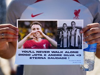 Fanúšik drží transparent s fotografiami Dioga Jotu a Andrého Silvu