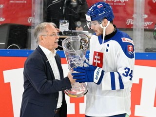 Prezident Nemeckej federácie ľadového hokeja Peter Merten odovzdáva víťaznú trofej do rúk kapitána slovenskej hokejovej reprezentácie Petra Cehlárika za víťazstvo na medzinárodnom hokejovom stretnutí o Nemecký pohár.