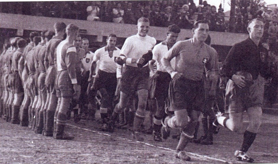 Kapitán Ivan Chodák privádza tím Slovenska na prvý medzištátny zápas 27.8.1939 v Bratislave na Tehelnom poli proti Nemecku.