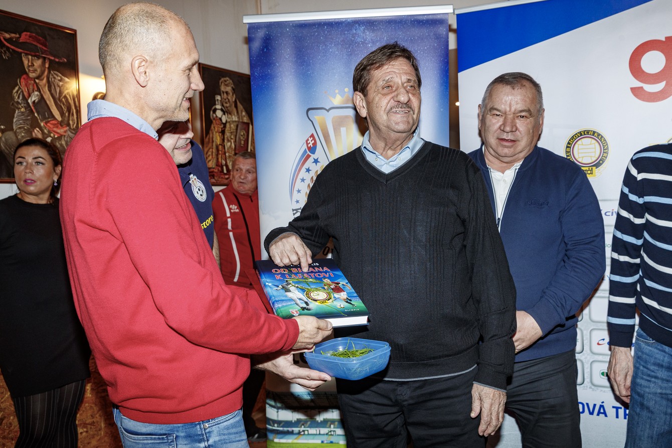 Futbalová kniha posypaná futbalovou trávou, zľava Tomáš Medveď, Ján Čapkovič, Peter Herda.