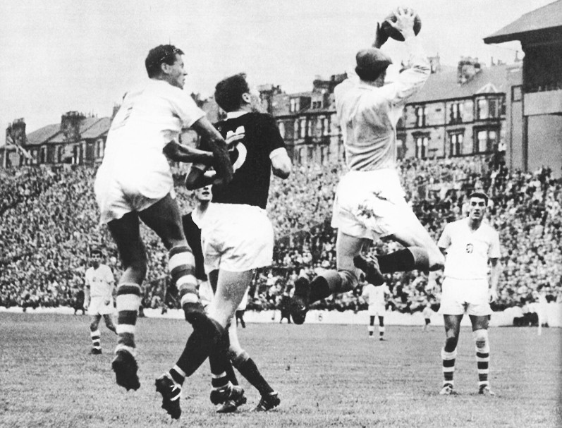 V kvalifikačnom zápase o postup na MS 1962 brankár Brown sťahuje loptu pred Buberníkom, situáciu sleduje Kvašňák. (Glasgow, 26.09.1961).