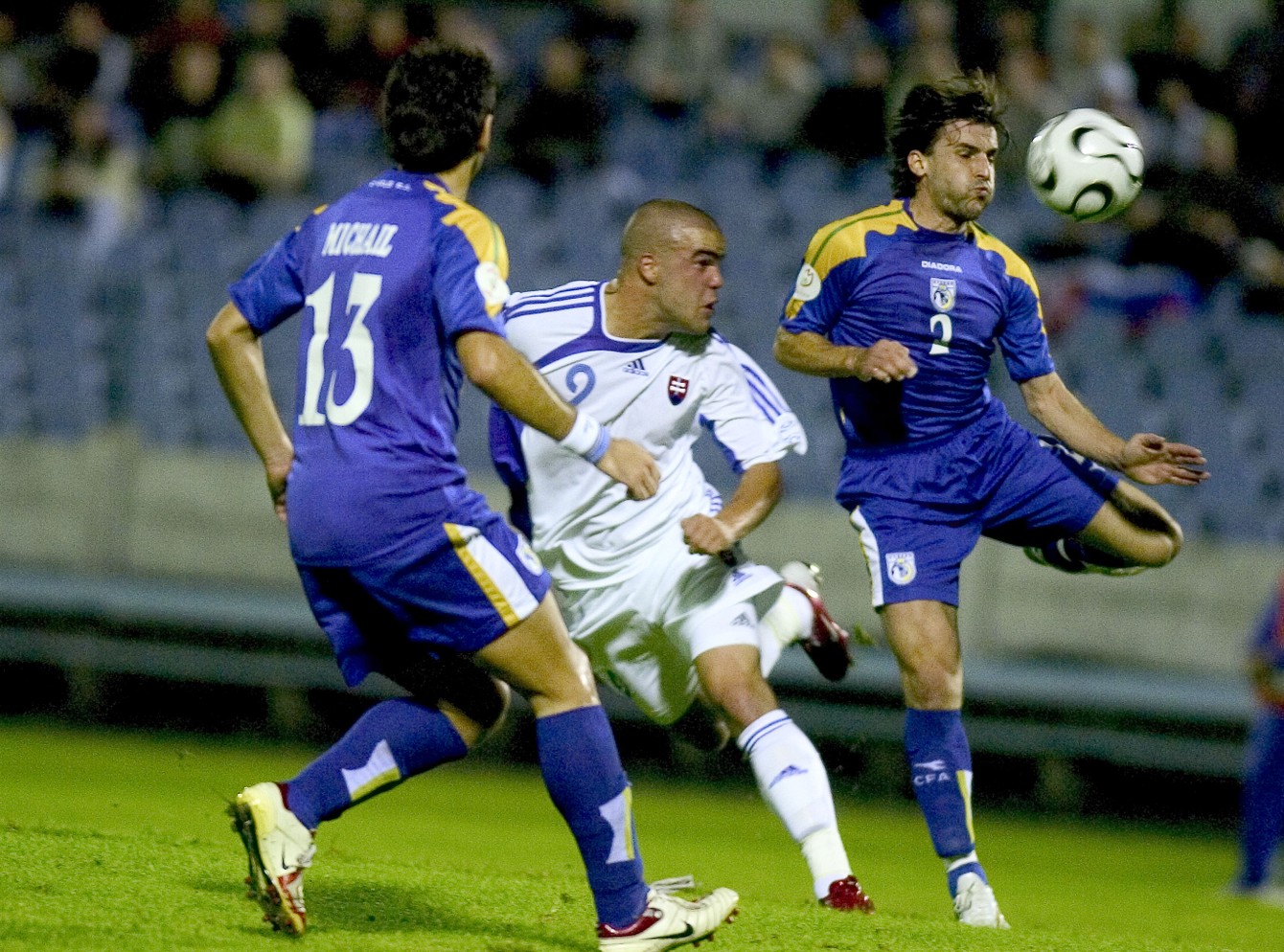 Filip Šebo v súboji s cyperskými hráčmi Michailom (č.13) a Theodotouom (č. 2) v zápase Slovensko – Cyprus 6:1 v Bratislave (02.09.2006).