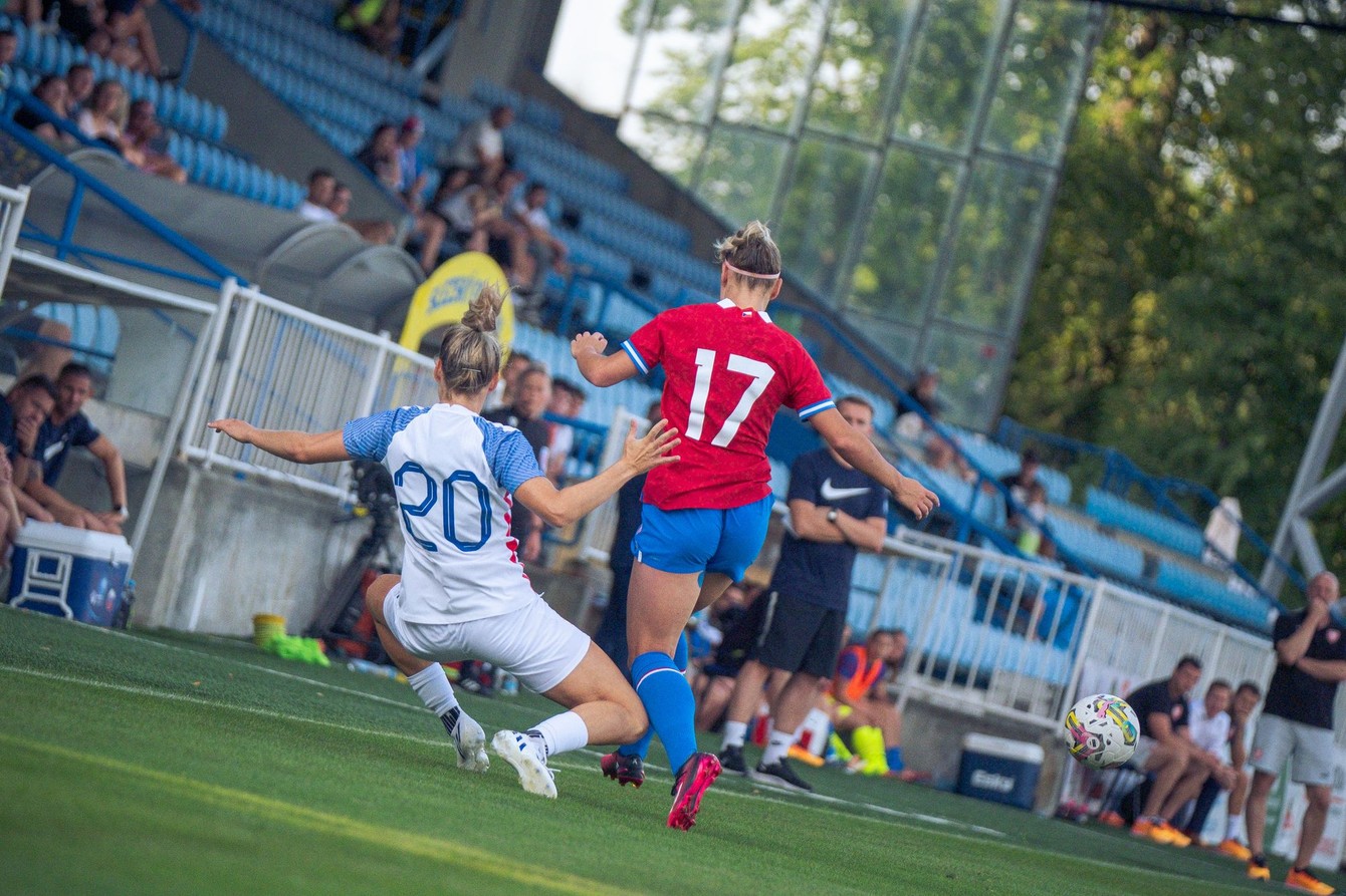 Jana Vojteková (č. 20) v obrannom zákroku pred Kristýnou Růžičkovou, od lavičky sa prizerá tréner Peter Kopúň.