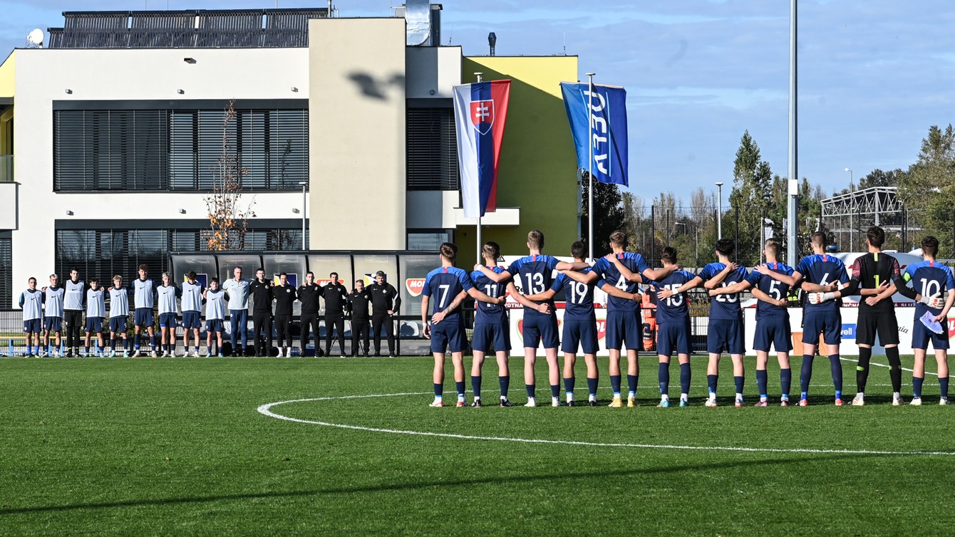 Celý tím, zákaldná zostava na ihrisku, ďalší hráči a realizačný tím na lavičke pri slovenskej hymne.