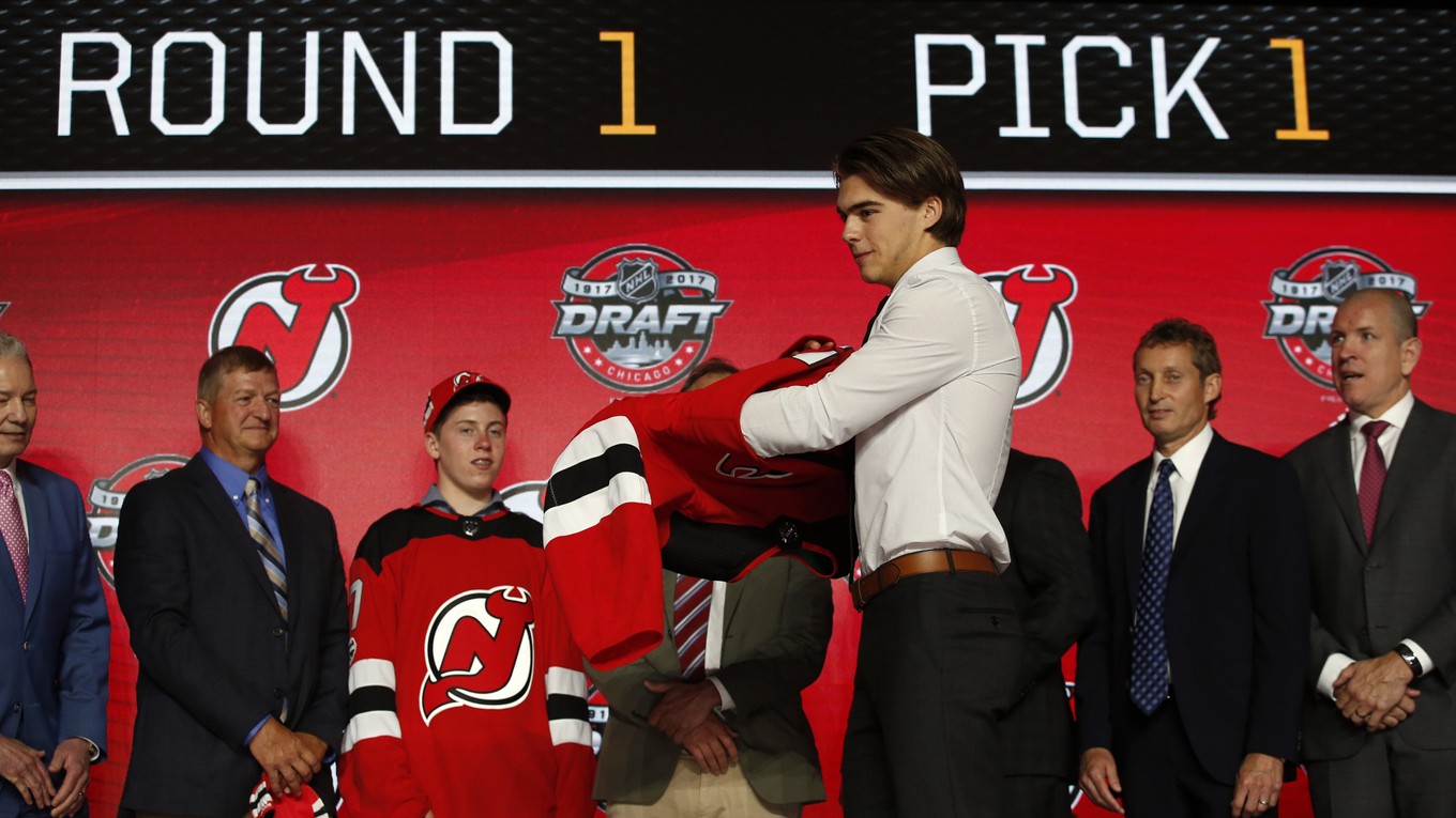 Nico Hischier (v popredí) si oblieka dres New Jersey Devils.