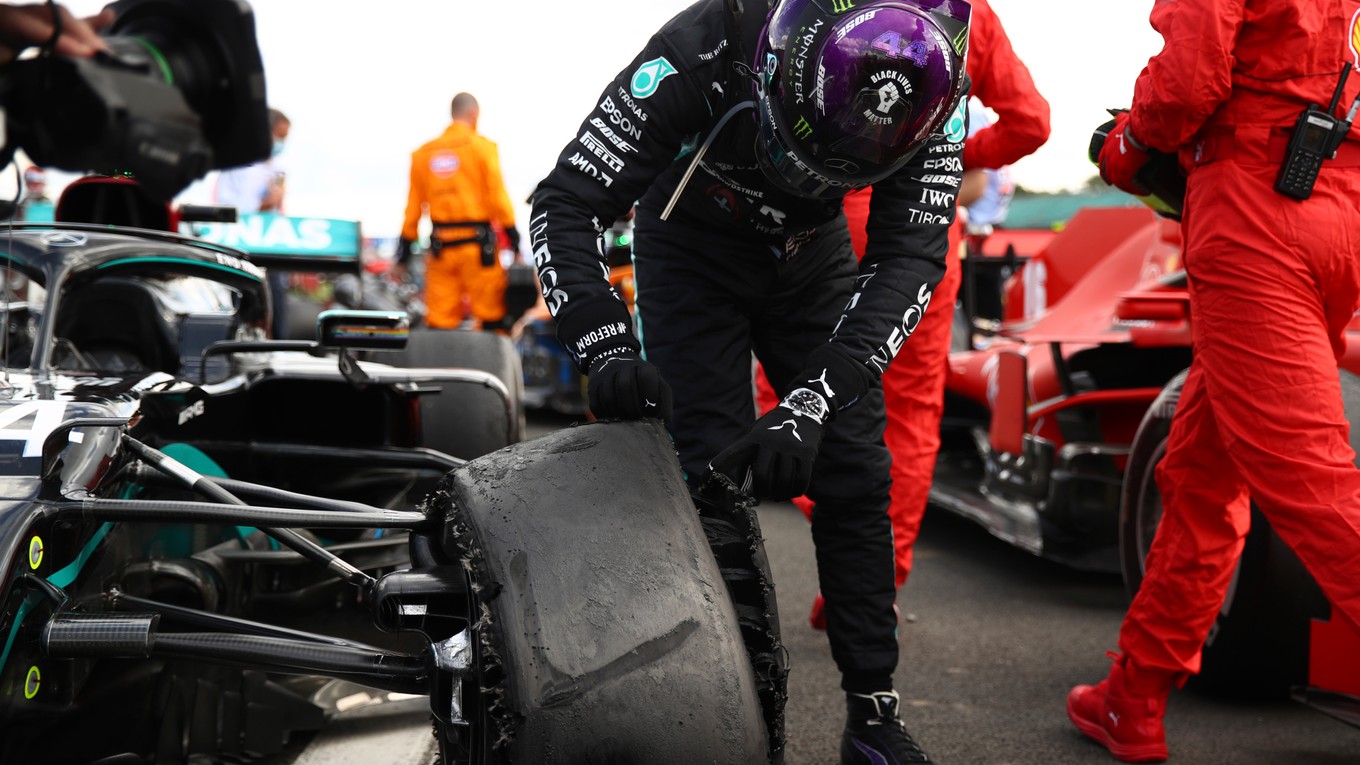 Lewis Hamilton si obzerá zničenú pneumatiku.