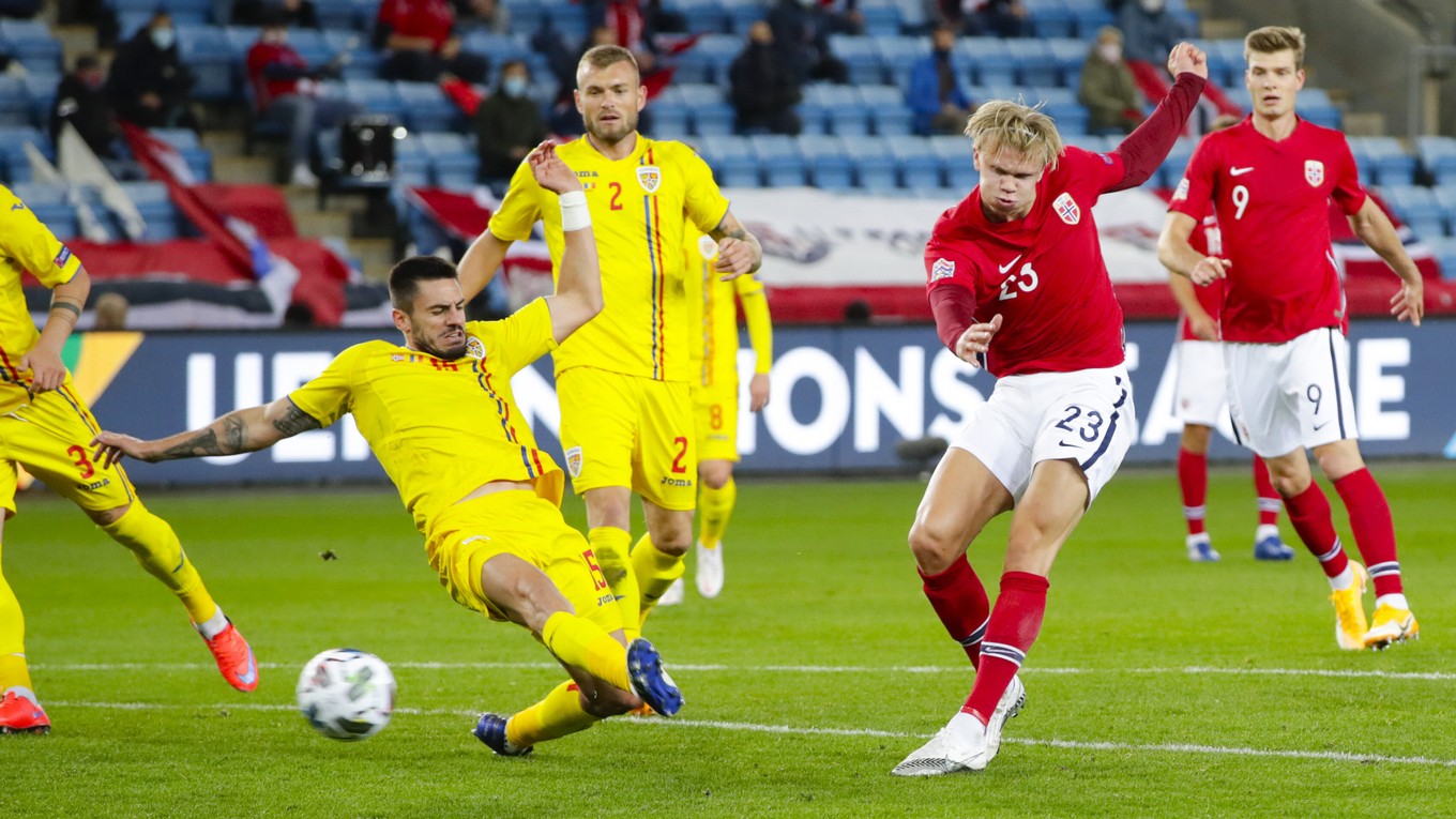 Erling Braut Haaland (Nórsko) strieľa gól v zápase Rumunsko - Nórsko v Lige národov. Bráni Andrei Burca (Rumunsko).