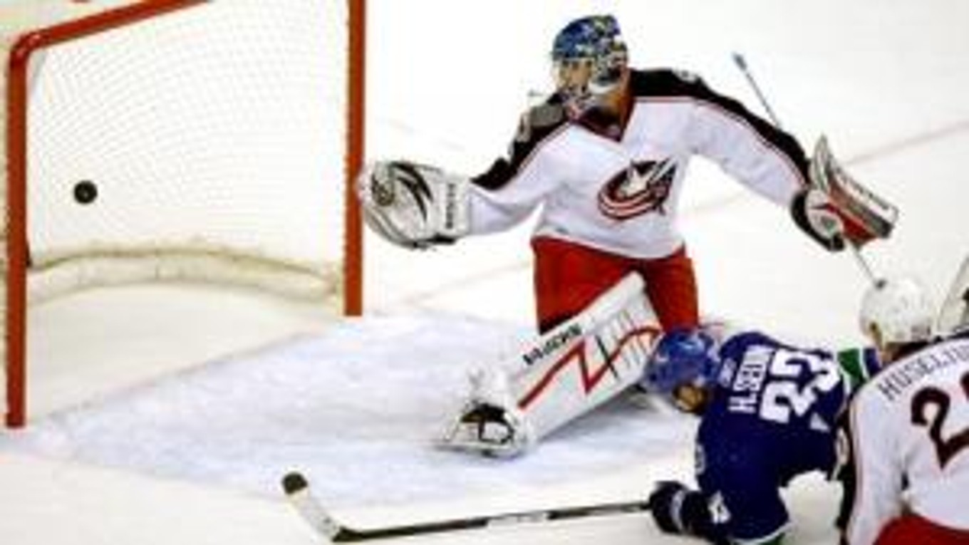 Henrik Sedin z tímu Vancouver Canucks dáva gól do bránky brakára mužstva Columbus Blue Jackets Steva Masona.