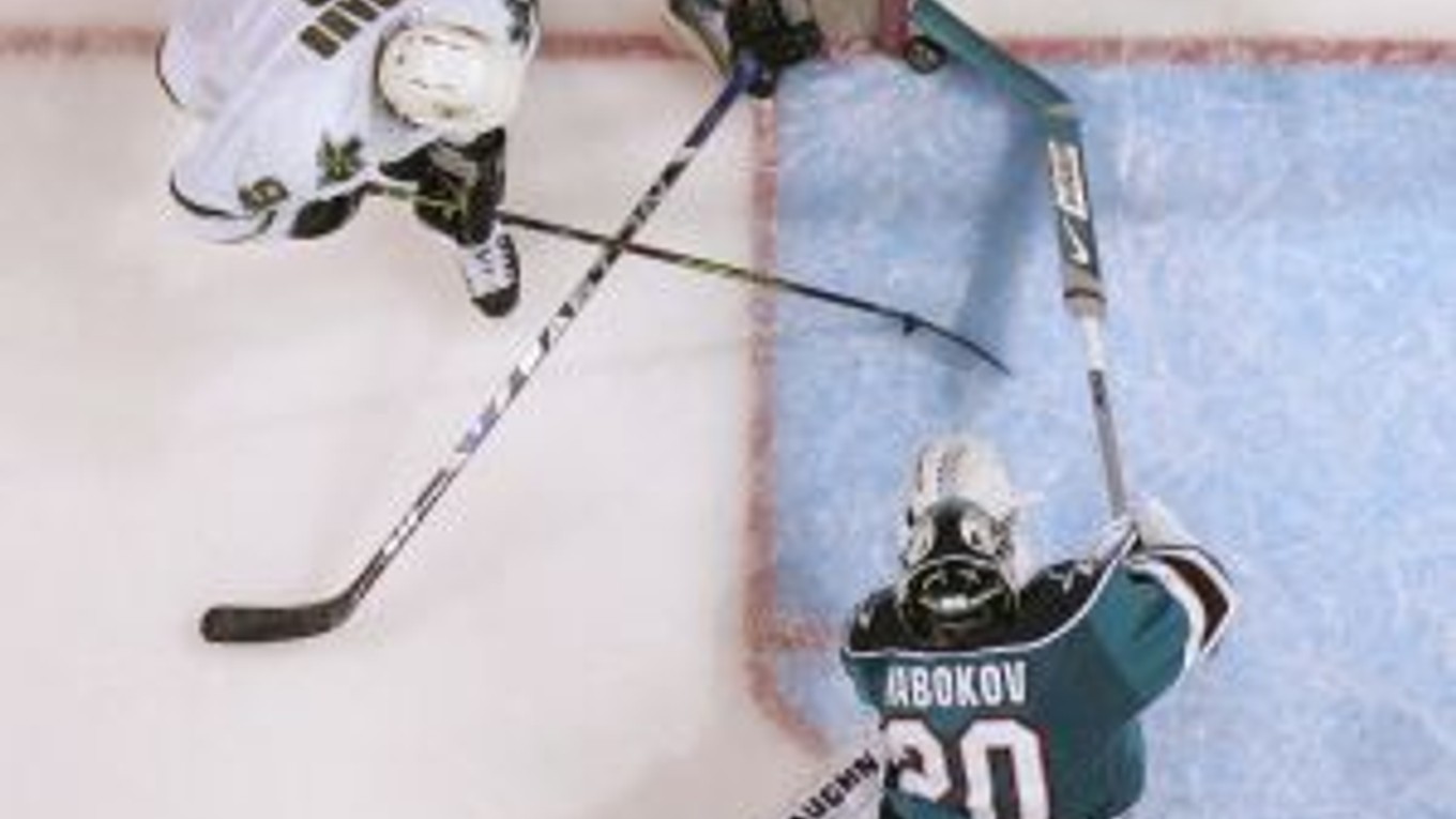 Brankár San Jose Sharks Jevgenij Nabokov zabraňuje pokusu hviezdy Dallas Stars Mike Modana (9). Na snímke je ešte spuluhráč kazašského gólmana Jeremy Roenick (27).