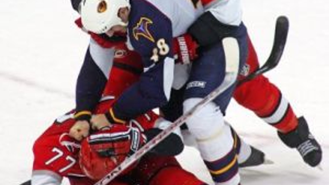 Niclas Wallin (7) z Caroliny oddeľuje slovenského obrancu Atlanty Borisa Valábika (48) od spoluhráča Joea Corva (77).