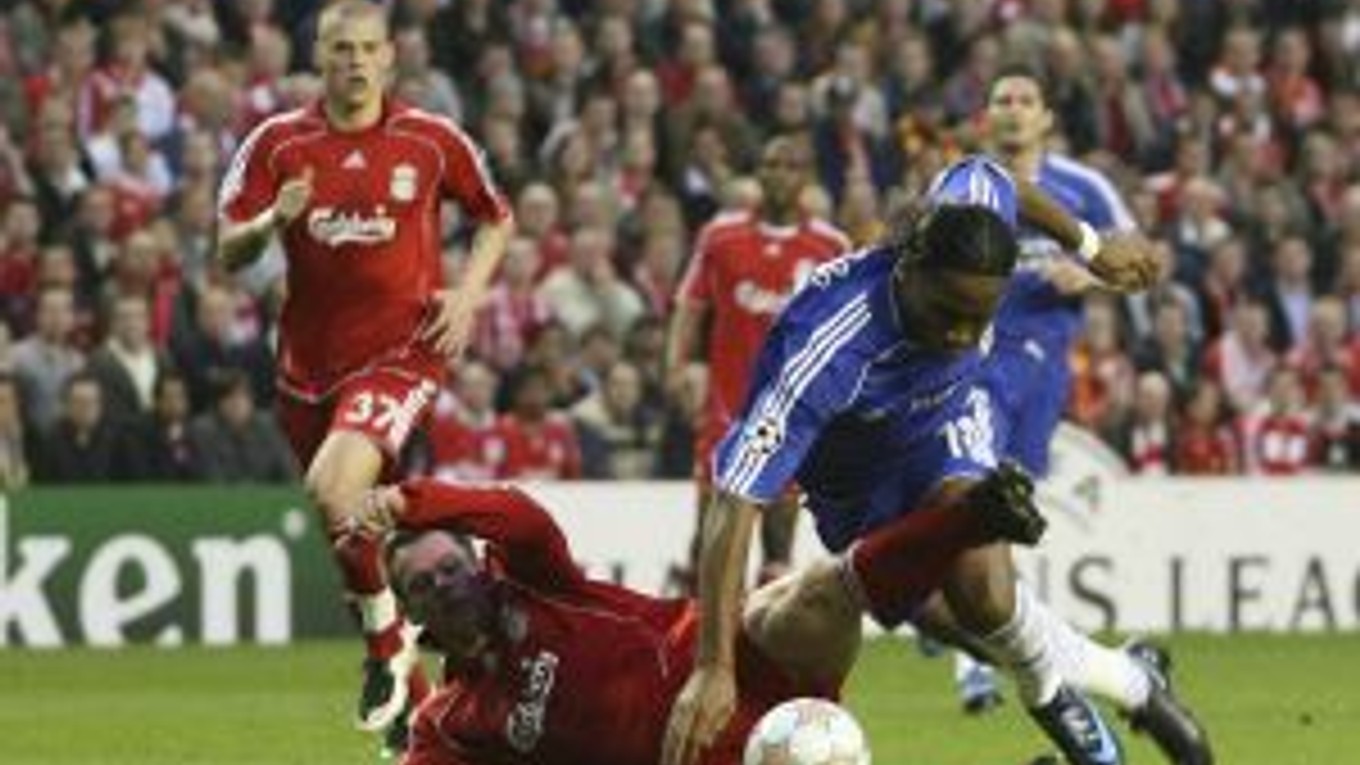 Jamie Carragher sa sklzom snaží zastaviť Didiera Drogbu. Situácii sa prizerá slovenský stopér Martin Škrtel.