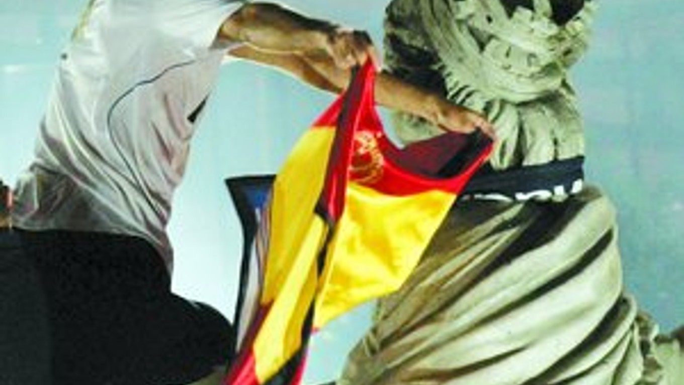 Kapitán Raúl oblieka sochu Cibeles do klubového šálu a španielskej vlajky.