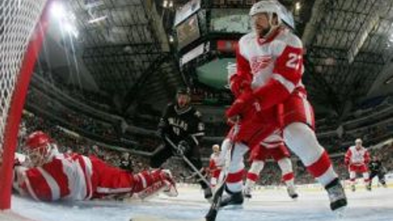 Obranca Detroitu Brad Stuart a brankár Chris Osgood zabránili puku v smerovaní do brány.