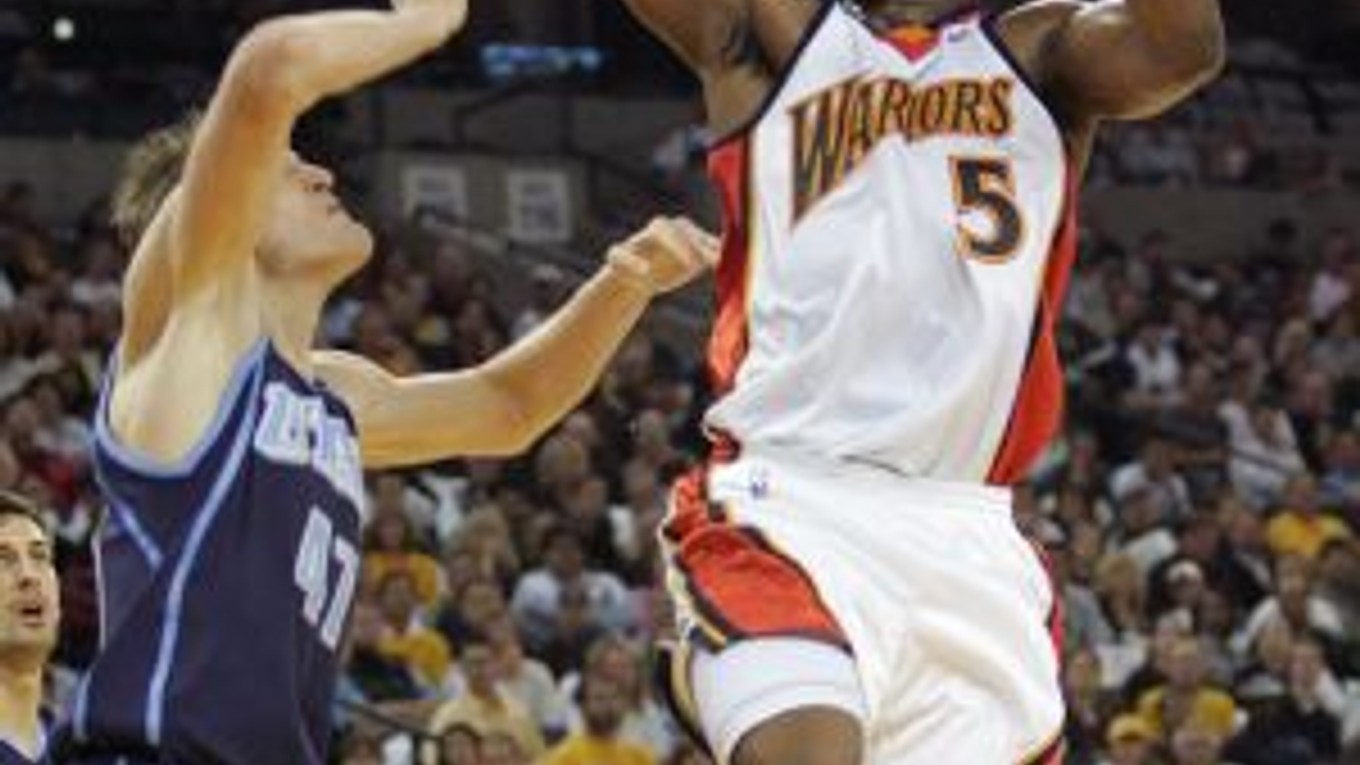 Baron Davis z Golden State Warriors (vpravo) zakončuje cez Andreja Kirilenka z Utah Jazz.