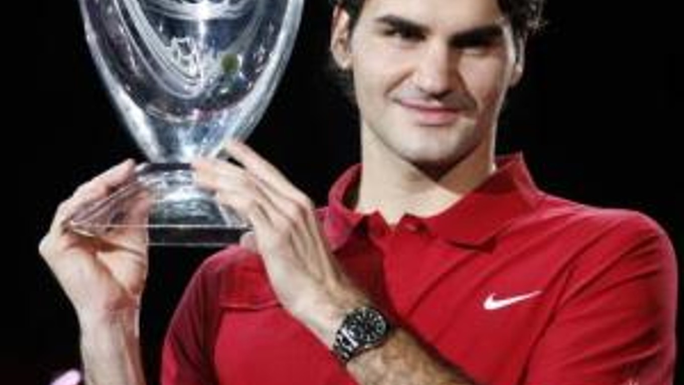 Roger Federer pózuje fotografom s víťaznou trofejou.