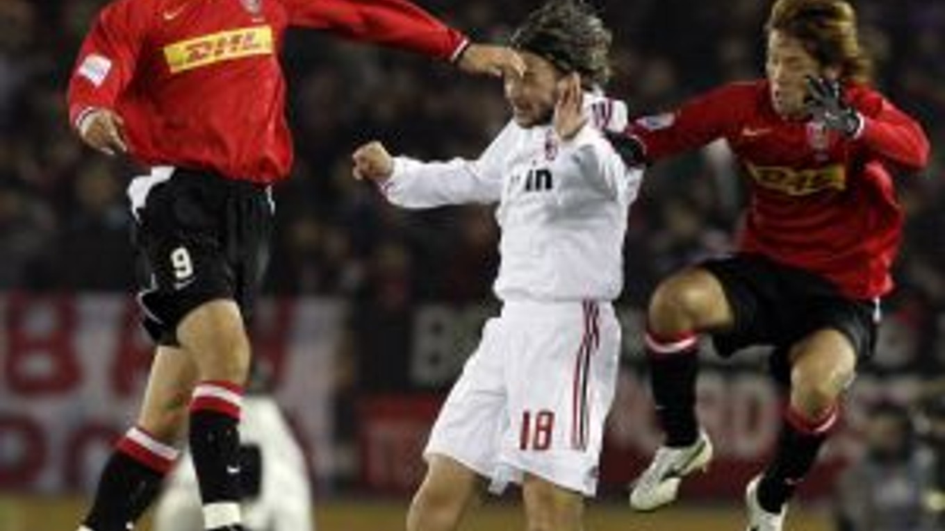 Obranca milánskeho AC Marek Jankulovski (v bielom) v súboji s dvojicou hráčov Urawy počas semifinálového stretnutia MS klubov.