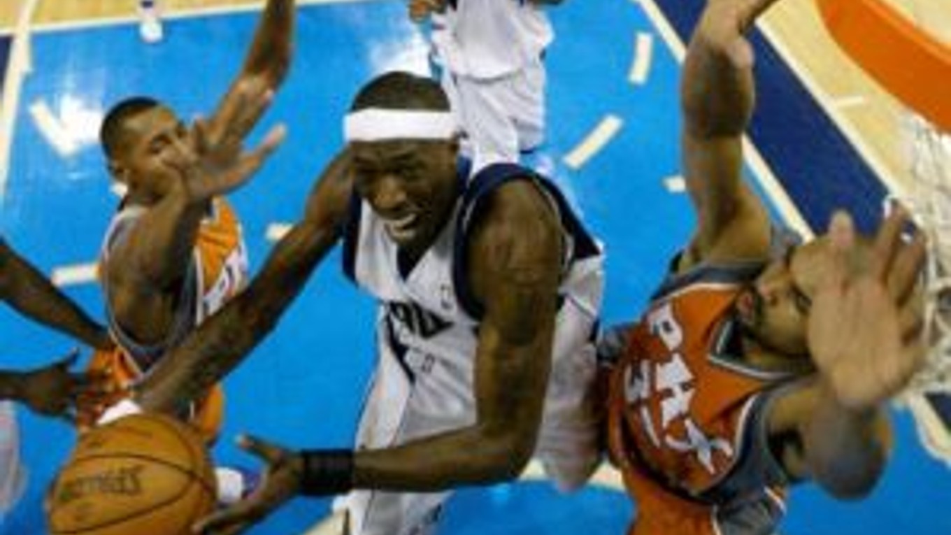 Josh Howard (v bielom) z Dallasu Mavericks sa snaží zakončiť cez hráča Phoenixu Borisa Diawa.
