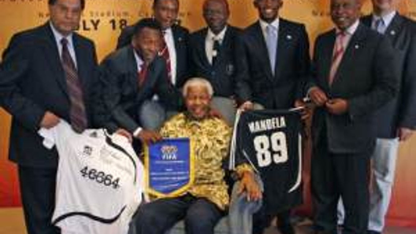 Bývalý juhoafrický prezident Nelson Mandela (sediaci) pózuje s brazílskou futbalovou legendou Pelém (druhý zľava) a predstaviteľmi FIFA 2010 v Johannesburgu 17.júla 2007 pred zápasom Afrika : zvyšok sveta pri príležitosti 89.narodenín Mandelu