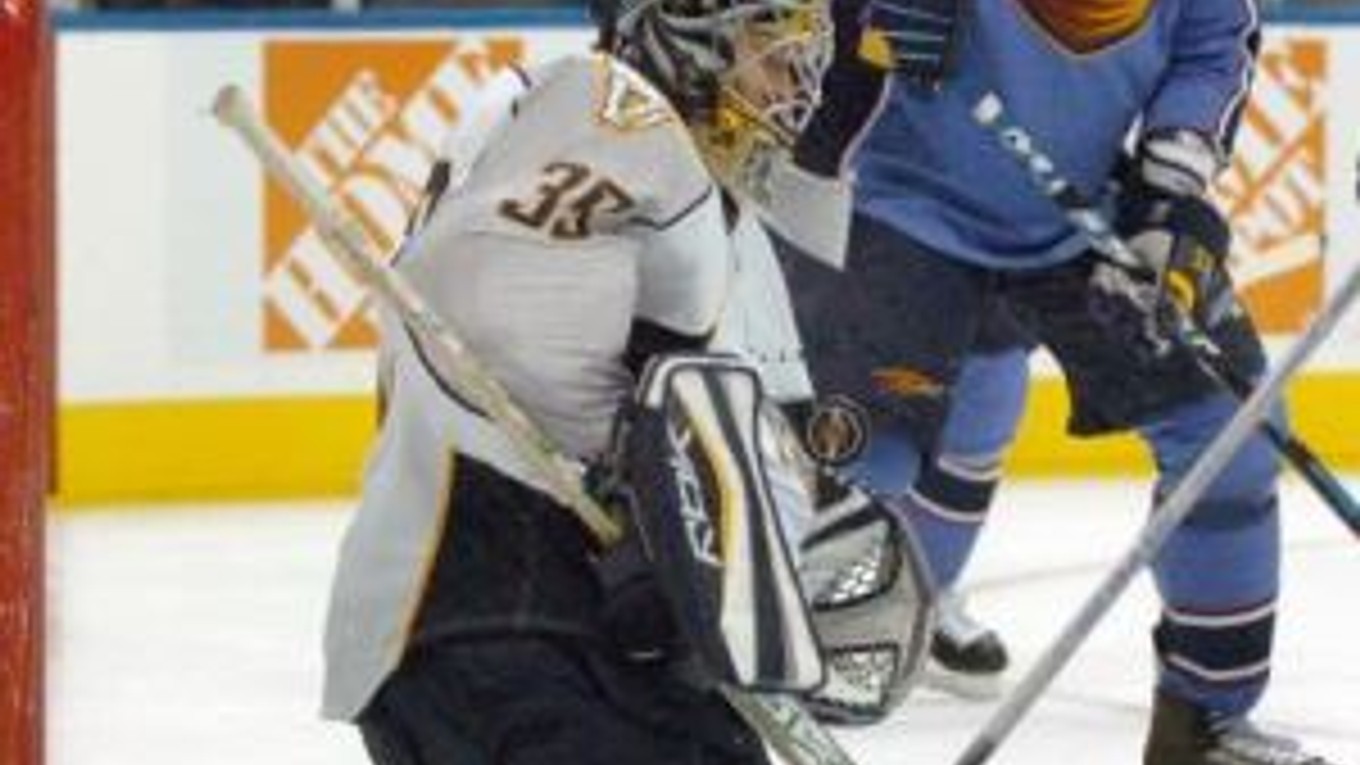 Brankár Nashville Dan Ellis odráža strelu pred slovenským hráčom Atlanty Mariánom Hossom v prípravnom zápase NHL v Atlante 25.septembra 2007