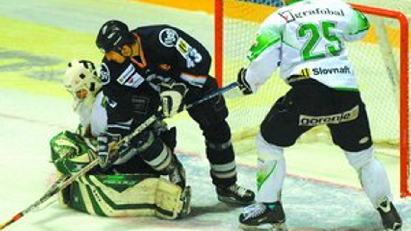 Košičan Peter Bartoš (v tmavom) číha na puk, ktorý zachytil brankár Skalice Peter Hamerlík. Vpravo je skalický obranca Martin Zajac. Košice vyhrali štvrťfinálovú sériu 4:1 na zápasy. FOTO - TASR