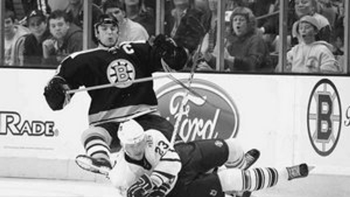 Zdeno Chára (vľavo) z Boston Bruins padá v súboji s Alexejom Ponikarovským z Toronto Maple Leafs. Boston prehral 4:6.