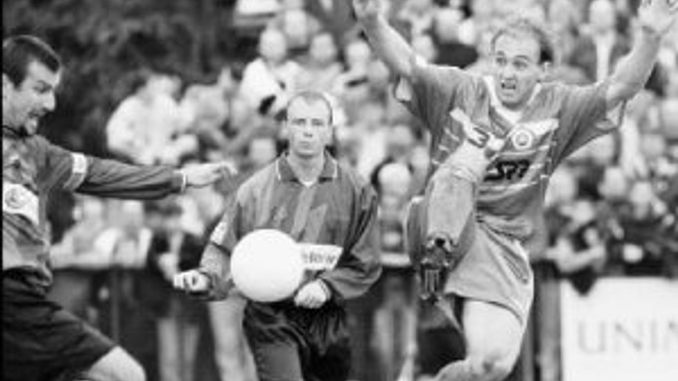 Kapitán Artmedie Bratislava v roku 1998 Martin Kuna (vľavo) odkopáva loptu pred útočníkom Slovana Miroslavom Krissom (vpravo). V strede sleduje akciu Martin Karnas.