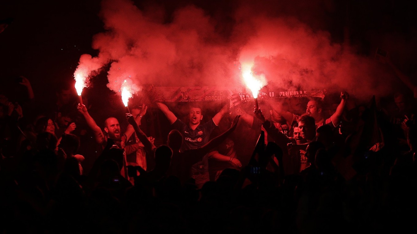 Fanúšikovia Barcelony mávajú zapálenými svetlicami a oslavujú majstrovský titul.