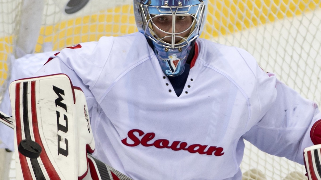 Brankár Slovana Michael Garnett zasahuje vyrážačkou.