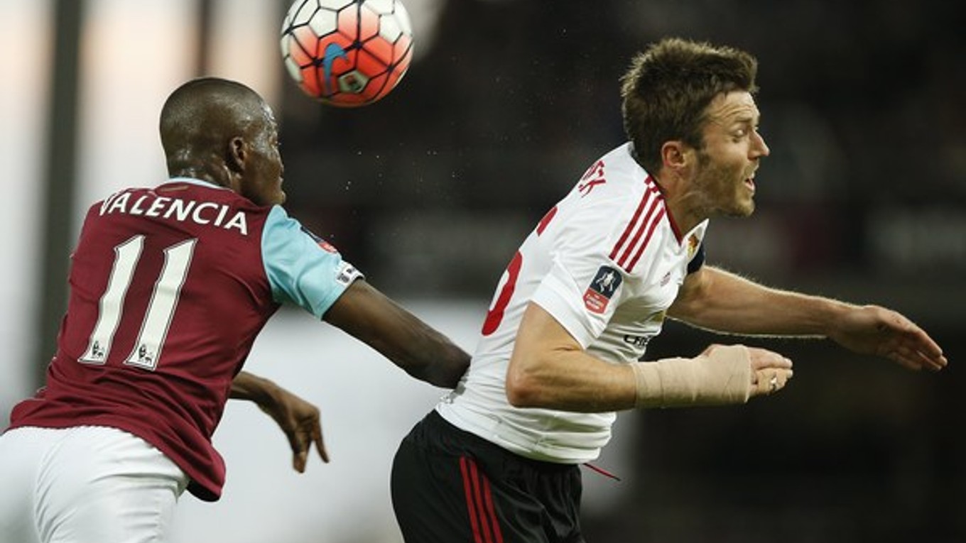 Na snímke vpravo hráč United Michael Carrick a vľavo hráč West Hamu Enner Valencia.