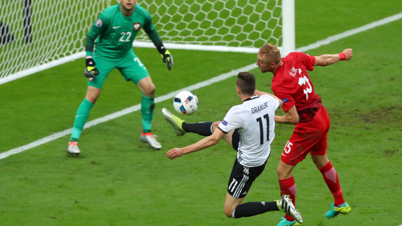 Nemec Julian Draxler (s číslom 11) sa pokúša zakončiť pred poľským brankárom Lukaszom Fabianským počas zápasu Nemecko - Poľsko na ME 2016. Bráni ho Kamil Glik.
