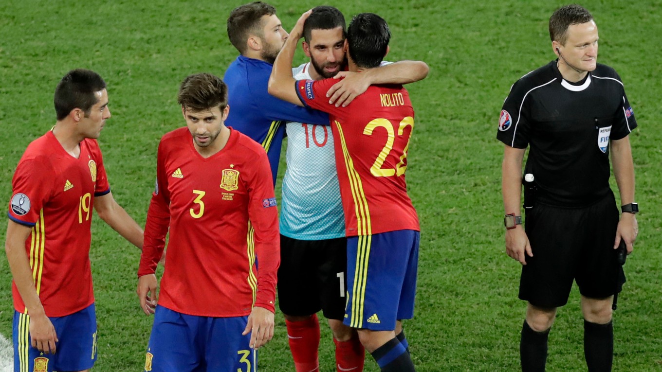 Turek Arda Turan sa po zápase objíma so španielskym krídelníkom Nolitom.
