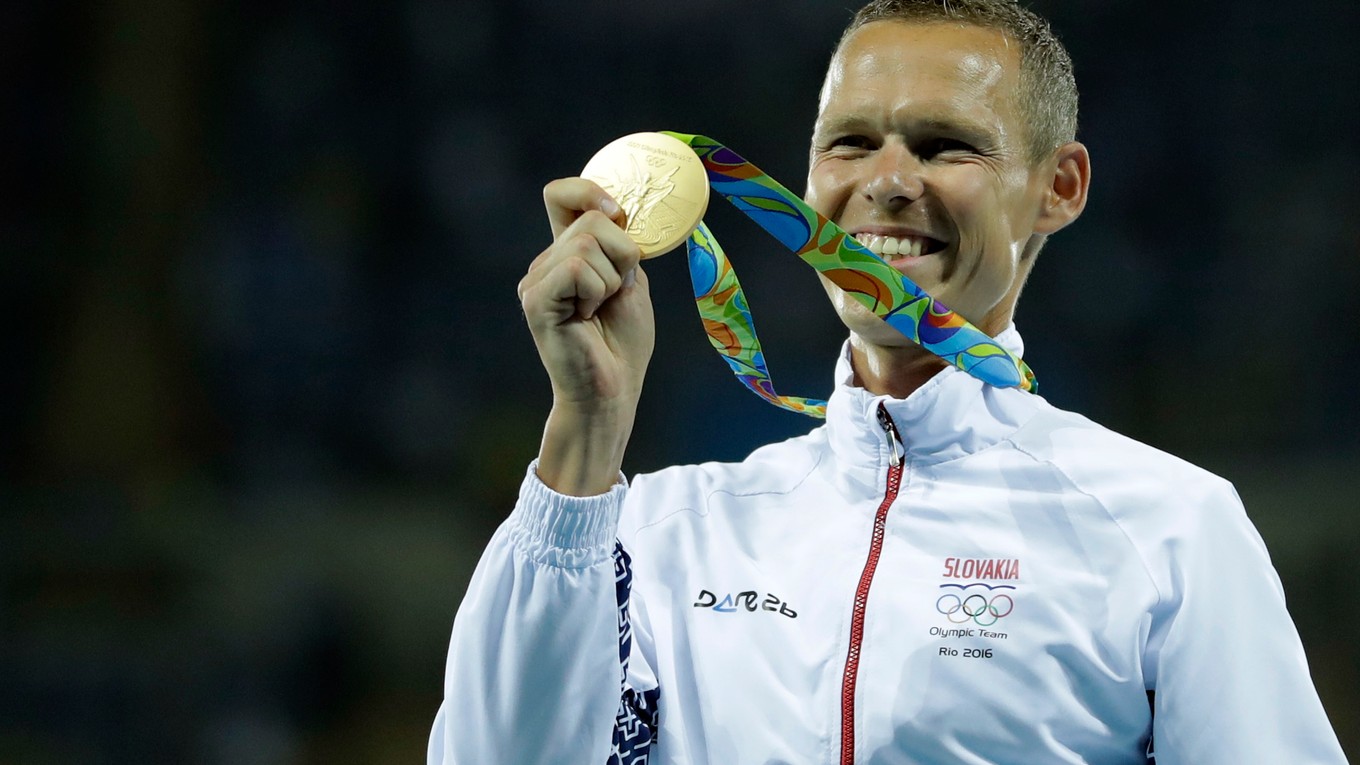 Matej Tóth pózuje so zlatou olympijskou medailou.