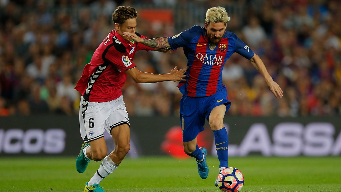 Lionel Messi z FC Barcelona (vľavo) v súboji o loptu s Marcosom Llorentem z Alavesu.