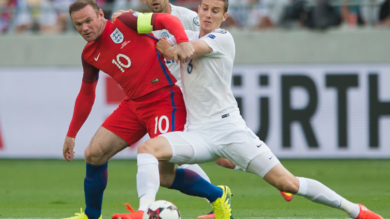 Wayne Rooney (vľavo) mal na ruke kapitánsku pásku aj v kvalifikačnom zápase proti Slovensku. Na snímke sa ho od lopty pokúša odstaviť Ján Greguš.