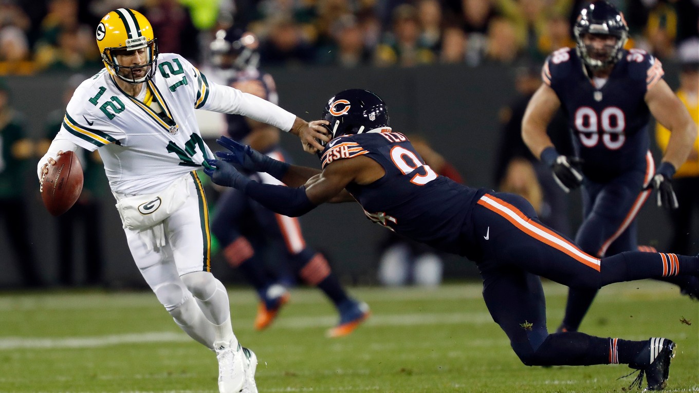 Hviezdneho quarterbacka tímu Green Bay Packers Aarona Rodgersa (vľavo) sa pokúša zložiť na zem hráč Chicaga Bears Leonard Floyd.
