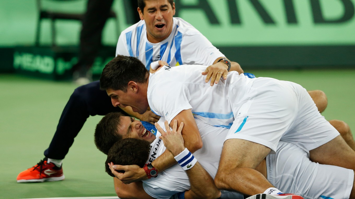 Tenisti a tréneri Argentíny sa radujú po rozhodujúcej výhre Delbonisa.